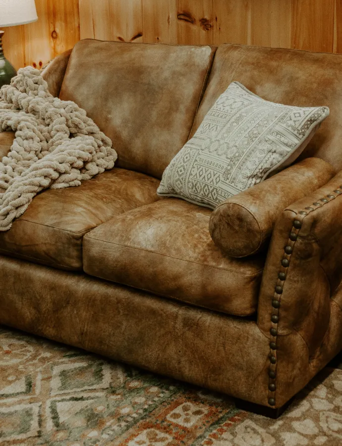 Brown tufted leather loveseat